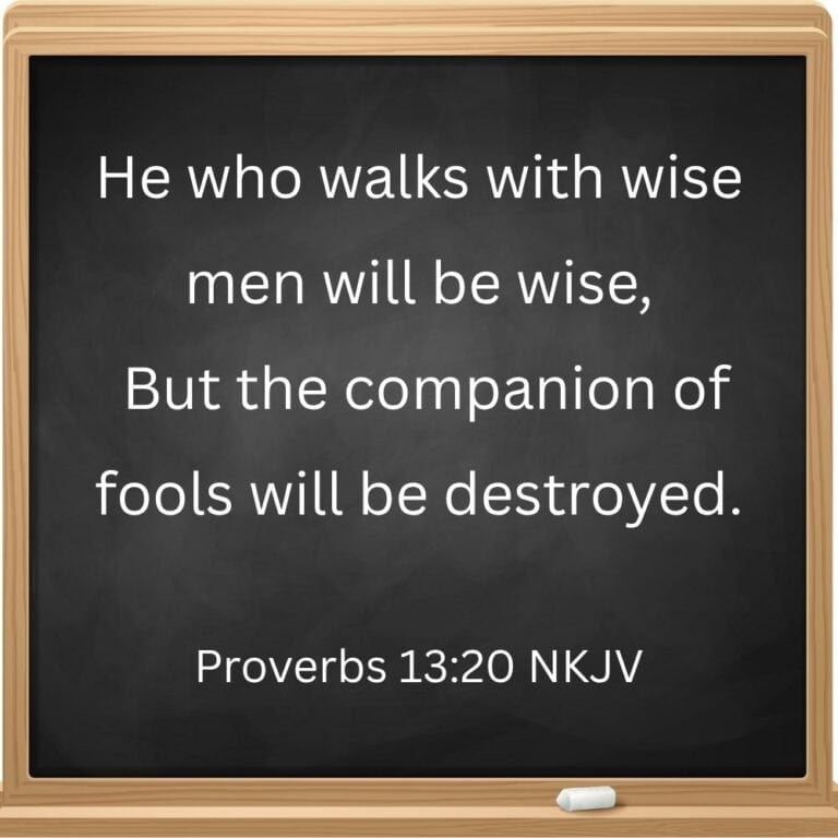 Bible verse for back to school prayers post. This shows a square chalkboard with a wooden border and one piece of chalk. The Bible verse Proverbs 13:20 is written on the board in chalk.