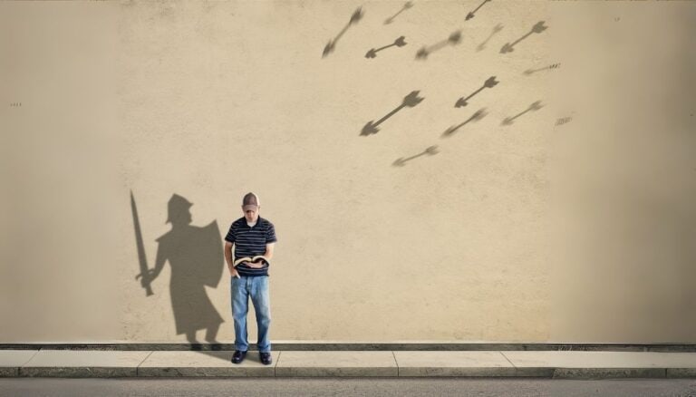 Featured image for the Armor of God post. The picture shows a young man dressed in blue jeans, a t-shirt, and a baseball hat. He is standing up and is reading a Bible in his hand. The shadow behind shows a warrior with a sword and shield. In the top right of the picture, arrows of different sizes are flying towards the young man.