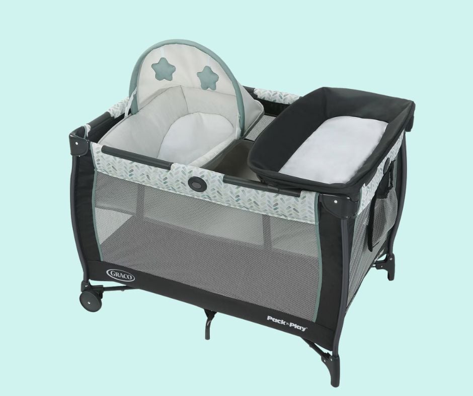 Picture of a baby Pack N Play bed. It is a black playpen with a changing pad and basinette that fit on the top. Used to illustrate baby gear for the post What does a first-time grandma need?