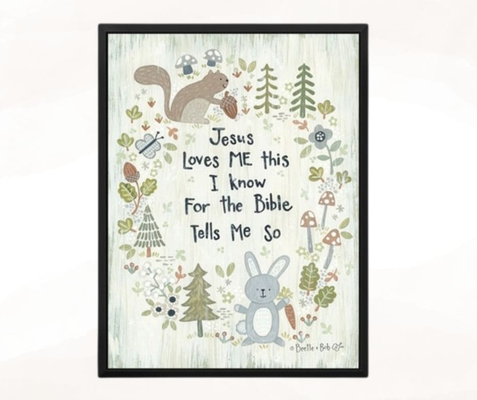 A wall hanging in a black frame that says Jesus Loves Me this I know For the Bible tells me so. The words are centered. In a circle around the words are forest trees and woodland animals, mushrooms and leaves. Used to illustrate the blog post : What does a first-time grandma need?