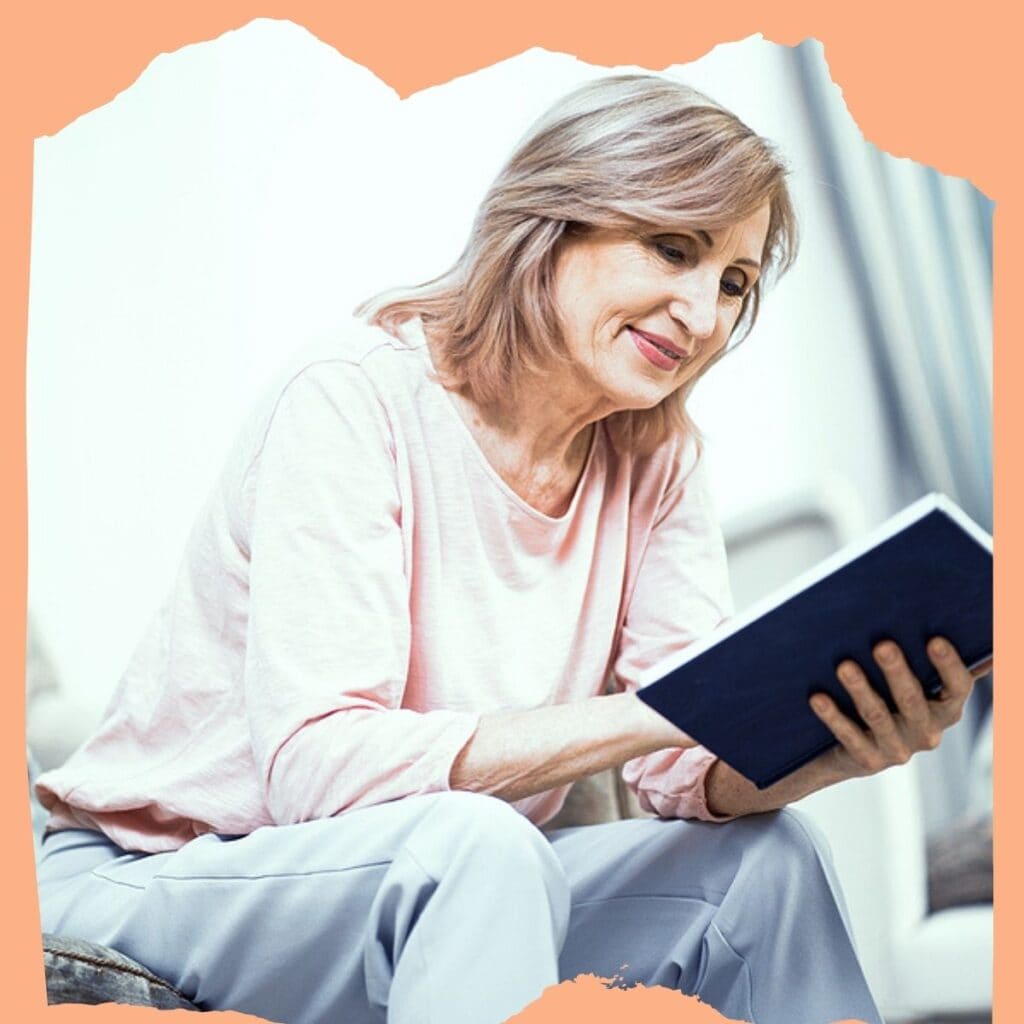 Photograph of a middle-aged woman reading a Bible and smiling. She is wearing comfortable clothes and seems very involved in her reading. Used to illustrate the post How to pray for your grandchildren's faith.