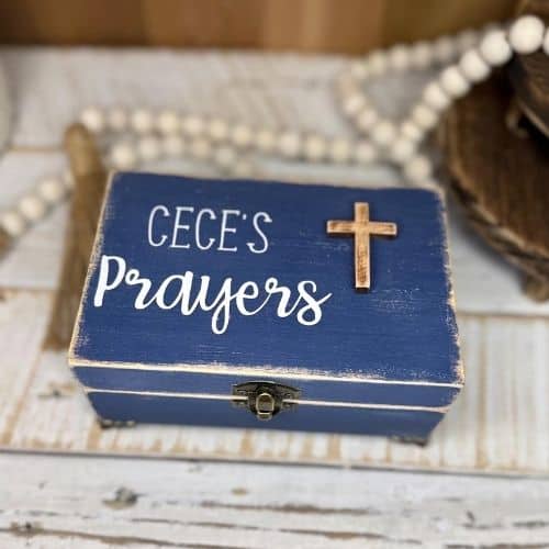 Photo of a prayer box. It's a blue wooden box with a gold cross on it. It has Cece's Prayers written on it. Used in the blog post Grandma's Prayer Jars.